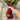 Hand extended holding and showing bunch of three Jannis Beetroots with leaves attached