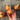 Hand holding Buan Onion over a wooden table to show side profile.