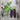 Two purple mangetout pea pods next to a flowering pea plant stem on a wooden table