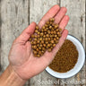 flat hand holding carlin peas over a wooden table