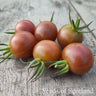 Six black cherry tomatoes grouped together on wooden table
