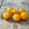 Six yellow cherry tomatoes grouped together on wooden table