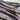 A close up of a bunch of purple and green Carters Polish Climbing French Beans on a wooden table