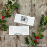 Gift voucher on a wooden surface with holly leaves and berries