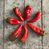 Red peppers arranged in a circular pattern on a wooden surface