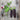 Two purple mangetout pea pods next to a flowering pea plant stem on a wooden table